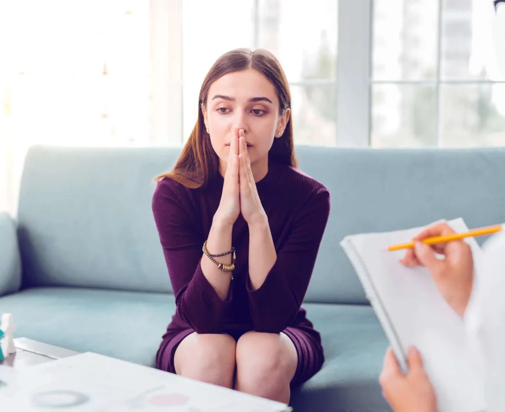 jeune femme anxieuse en séance avec psychologue mage-conseil à merignac, assise sur un canapé lumineux